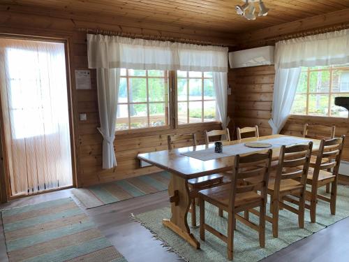 a dining room with a wooden table and chairs at Katriina, huom! sijaitsee saaressa, locates on island in Tahkovuori