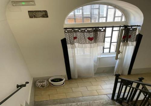 um corredor com um arco e uma porta com uma janela em La casa di nonna Maria em Nápoles