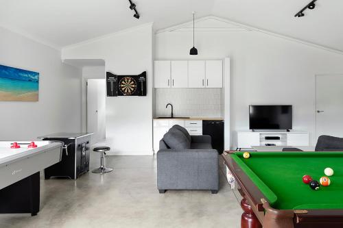 a living room with a pool table and a couch at Songbird I Private Properties in Yallingup