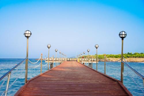 a wooden pier stretches out into the water at Oz Hotels Incekum Beach in Alanya