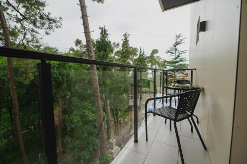 d'un balcon avec une chaise et une vue sur les bois. dans l'établissement Ritsa Resort, à Ureki