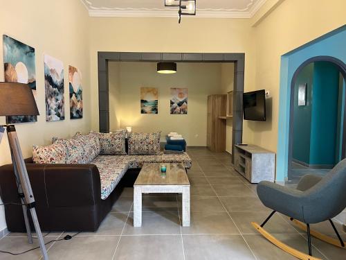 a living room with a couch and a tv at Spacious and beautiful house in Piraeus