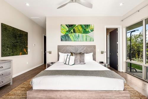 a bedroom with a large white bed and windows at Hapuna Modern House at Mauna Kea in Hapuna Beach