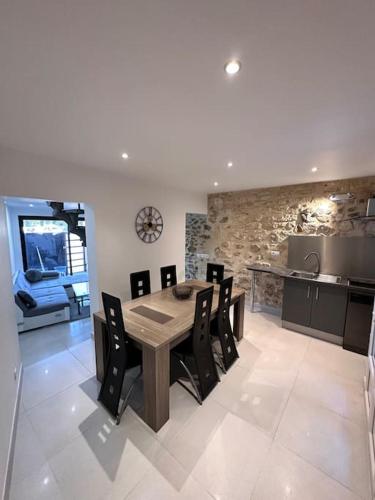 une cuisine et une salle à manger avec une table et des chaises dans l'établissement L’élégance de la pierre, à Fourques