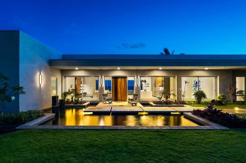 a house with a pond in front of it at Hapuna Modern House at Mauna Kea in Hapuna Beach