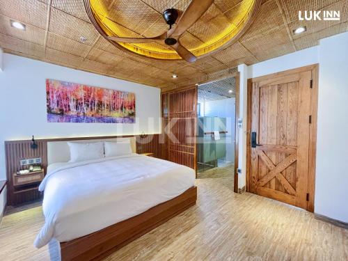 um quarto com uma cama grande e um tecto de madeira em LUK Inn Hotel em Da Nang