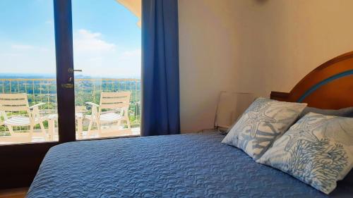 a bedroom with a bed and a large window at Golf & Sea Residence Is Molas in Pula