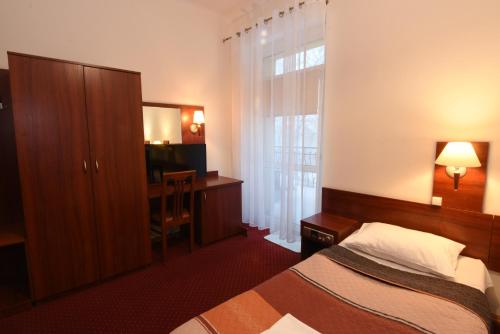 a bedroom with a bed and a desk and a window at Pegaz in Karpacz