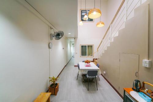 a dining room with a table and a staircase at Nut Home Hostel in Ban Ko
