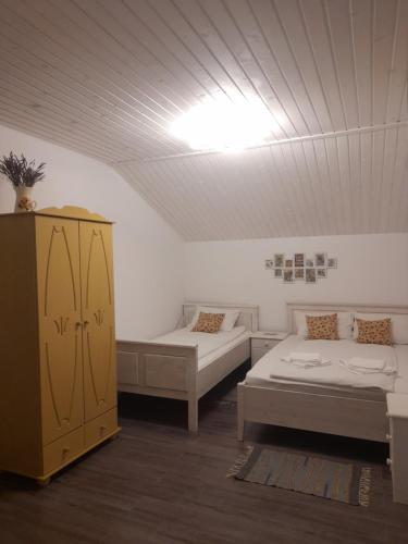 a room with two beds and a cabinet at Casa Davina in Sasca Montană