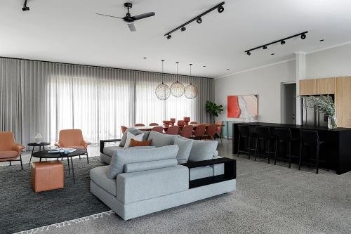 a living room with a couch and a dining room at Songbird I Private Properties in Yallingup