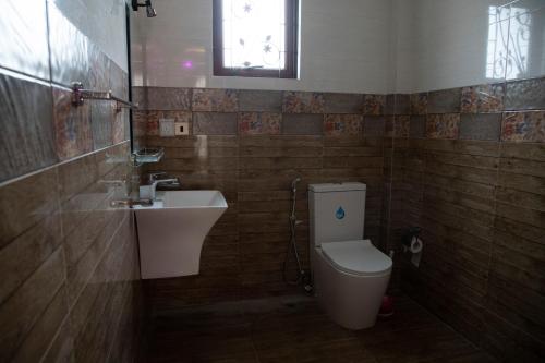 a bathroom with a toilet and a sink at WIMAL PALACE in Jaffna