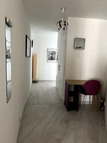 un couloir avec une table et une chaise dans une pièce dans l'établissement bel appartement climatisé centre, à Albi