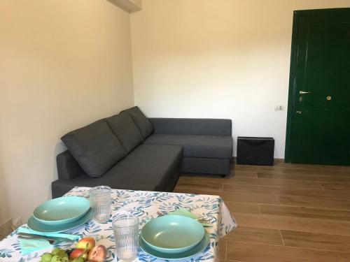 uma sala de estar com um sofá e uma mesa com pratos em Trilocale in residence Verdesirente em Rocca di Mezzo