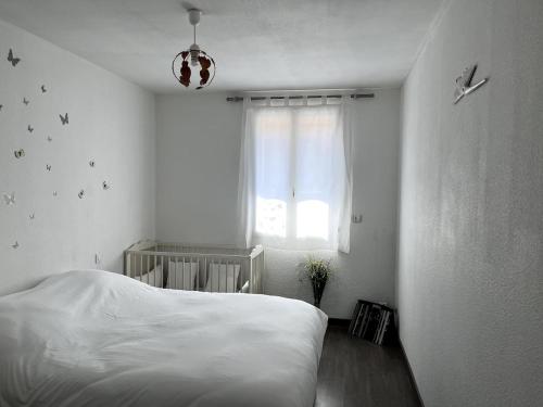 ein Schlafzimmer mit einem weißen Bett und einem Fenster in der Unterkunft bel appartement climatisé centre in Albi