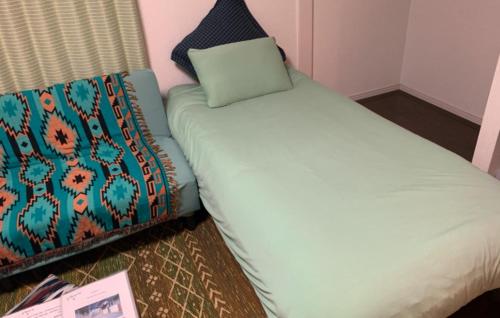 a bed with a pillow on top of it at Oyado Kinokuniya Daikokumachi in Nagasaki