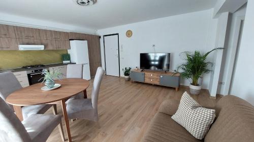 a living room with a table and a couch and a television at Apartament Monaco in Roman