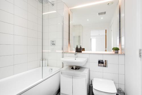 a white bathroom with a sink and a toilet at 3 bed luxury spacious apartment with pool in Manchester