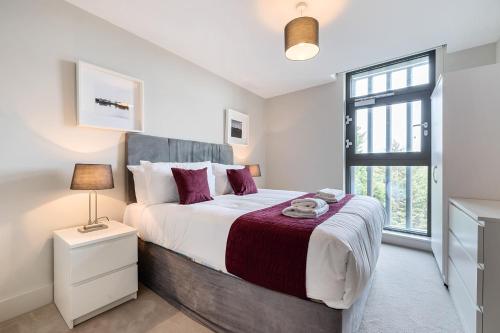 una camera con un grande letto e una finestra di Roomspace Serviced Apartments- Buttermere House a Kingston upon Thames