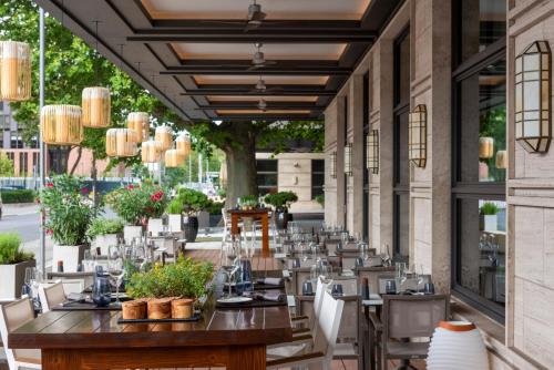 ein Restaurant mit Tischen und Stühlen auf einer Terrasse in der Unterkunft JW Marriott Hotel Berlin in Berlin