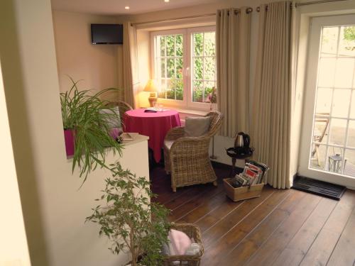 韋姆的住宿－La Cachette du Menuisier，客厅配有桌椅和窗户。