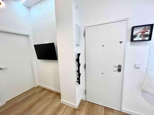 a room with a white door and a television at Acogedor apartamento 5 personas in Valencia