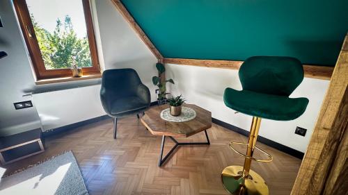 a living room with two chairs and a table at Uroczysko in Lesko