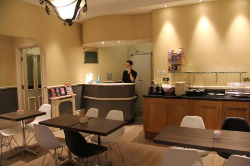 a woman standing at a counter in a restaurant at Columbus Hotel in London
