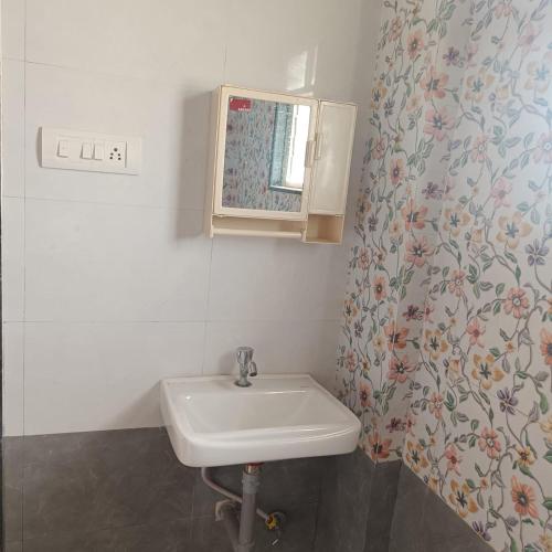 a bathroom with a sink and a mirror at Swapnashilp Bungalow in Hinjewadi