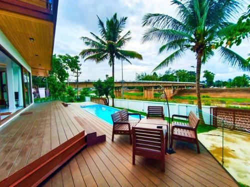 een terras met een tafel en stoelen en een zwembad bij Pool Villa Nam Nan in Nan