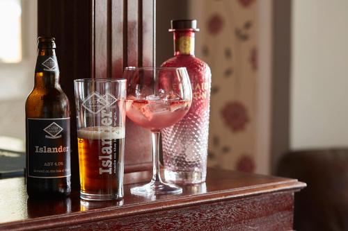 a bottle of alcohol and a glass of wine on a table at Luccombe Manor Country House Hotel in Shanklin
