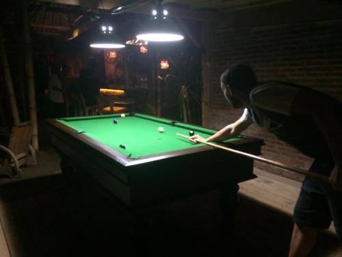 a man playing pool in a dark room at Palmyra Indah Bungalows in Sekotong