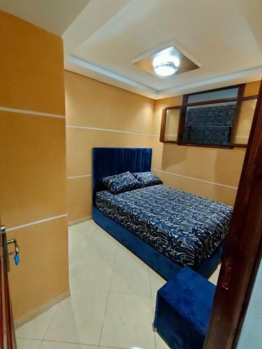 a small bedroom with a blue bed in a room at Appartement au sous-sol à mohammedia - wifi gratuit in Mohammedia