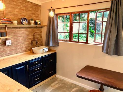 a kitchen with a sink and some windows at Modern Industrial Cottage in Kingsburgh