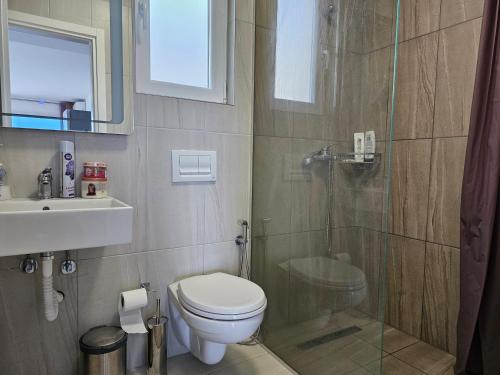 y baño con ducha, aseo y lavamanos. en Vista View Sunshine apartment, en Sarandë
