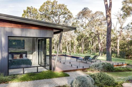 a house with a deck with a fireplace at Songbird I Private Properties in Yallingup
