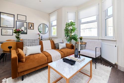 uma sala de estar com um sofá e uma mesa em The Kilburn Crib - Stunning 3BDR Flat em Londres