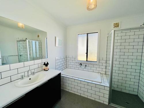 a white bathroom with a tub and a sink and a bath tub at ACACIA - 6 Joy Tce Pets Welcome outside in Robe