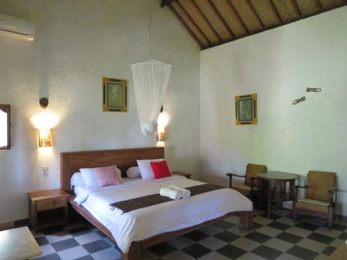 a bedroom with a bed and a table and chairs at Kebun Villa, Belimbing, Bali in Tabanan