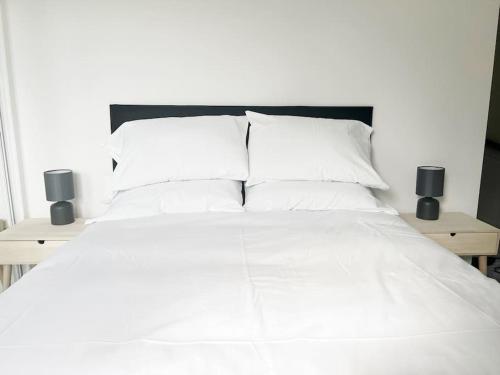 Una cama con sábanas blancas y almohadas. en Witton House by Blue Skies Stays, en Stockton-on-Tees