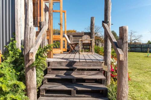 una escalera de madera que conduce a una casa con una valla en FreeFall Hut, en Hastings