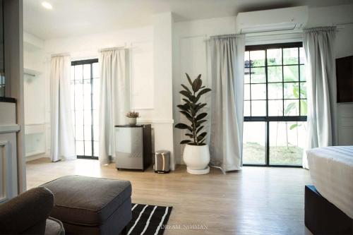 a living room with a bed and a large window at Dream Nimman Apartment in Chiang Mai
