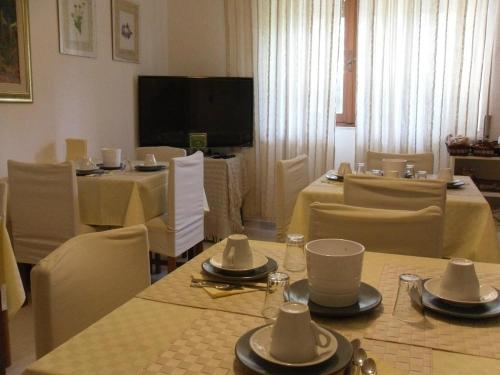 a dining room with tables and chairs and a television at B&B Fragus e Saboris de Sardigna in Sadali