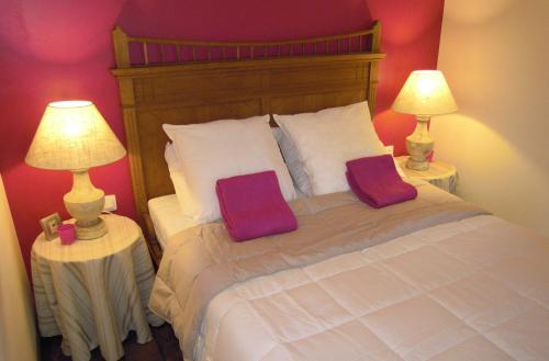 a bedroom with a bed with two pillows on it at La Cachette du Menuisier in Waimes