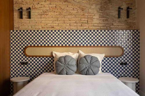a bed with two pillows on top of it at El Rincón de María Vicenta in Valencia