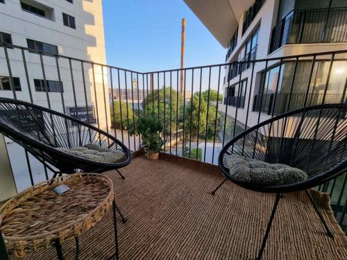 duas cadeiras sentadas na varanda de um edifício em Apartment Polina - 2BD Next to Sea Garden Varna em Varna City