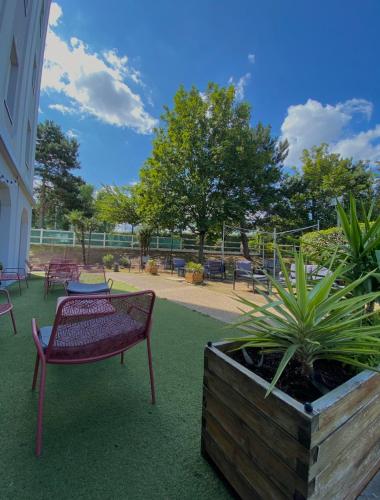 a patio with a bench and a table and plants at Campanile Blanc-Mesnil in Le Blanc-Mesnil