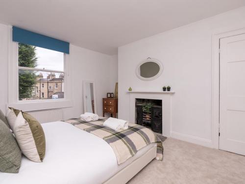 biała sypialnia z łóżkiem i kominkiem w obiekcie Pass the Keys Stylish apartment in Central Bath w mieście Bath