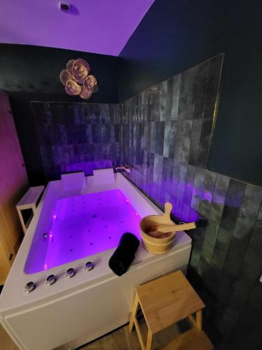 - une baignoire avec éclairage violet dans la chambre dans l'établissement Le SPEAK EASY / JACUZZI ET SAUNA, à Marseille