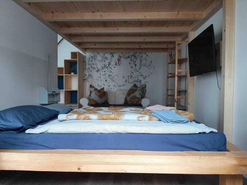 a bedroom with a large bed with a television on it at Artist Studio - Berlin - Prenzlauer Berg in Berlin